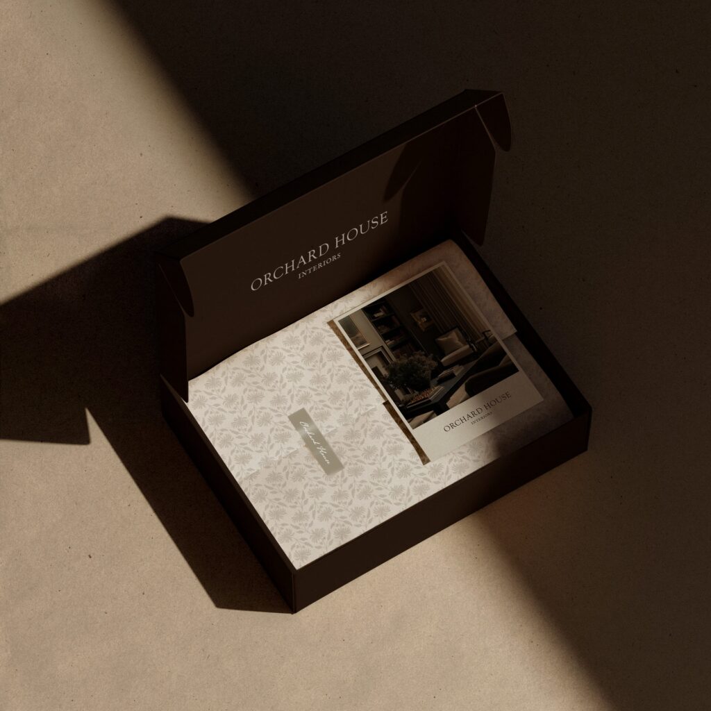 Luxury client onboarding package for Orchard House Interiors. Displays a branded presentation box with custom floral stationery and portfolio imagery, illustrating the premium brand experience.