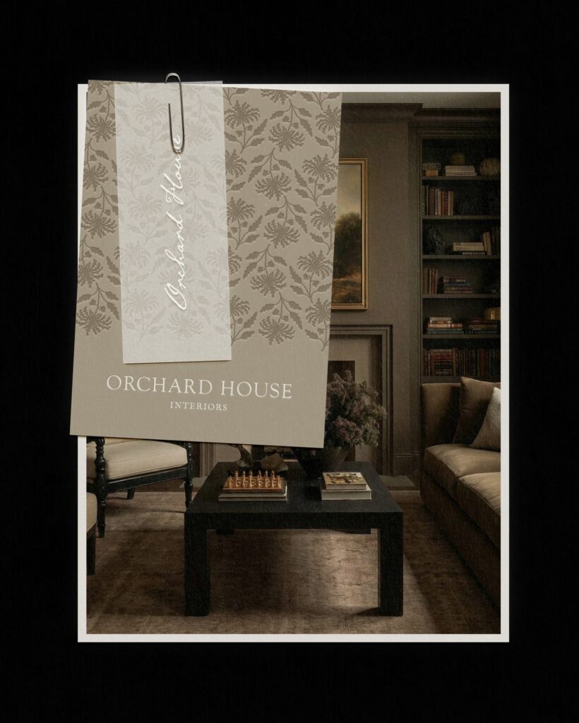 Atmospheric interior design graphic for Orchard House Interiors. The image features a paper-clipped branding card with a floral motif overlaying a photo of a moody, dark-toned library with floor-to-ceiling built-in bookshelves and a textured black coffee table.