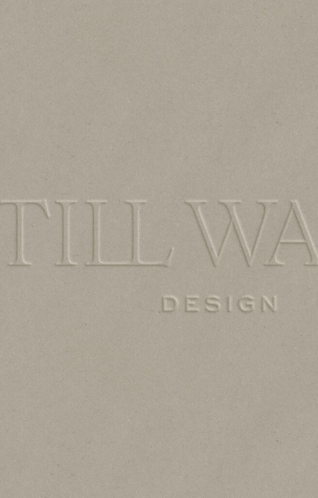 Detail shot of Stillwater Design branding, highlighting the tactile quality of blind embossed lettering on premium cardstock to convey a minimalist, refined brand identity.