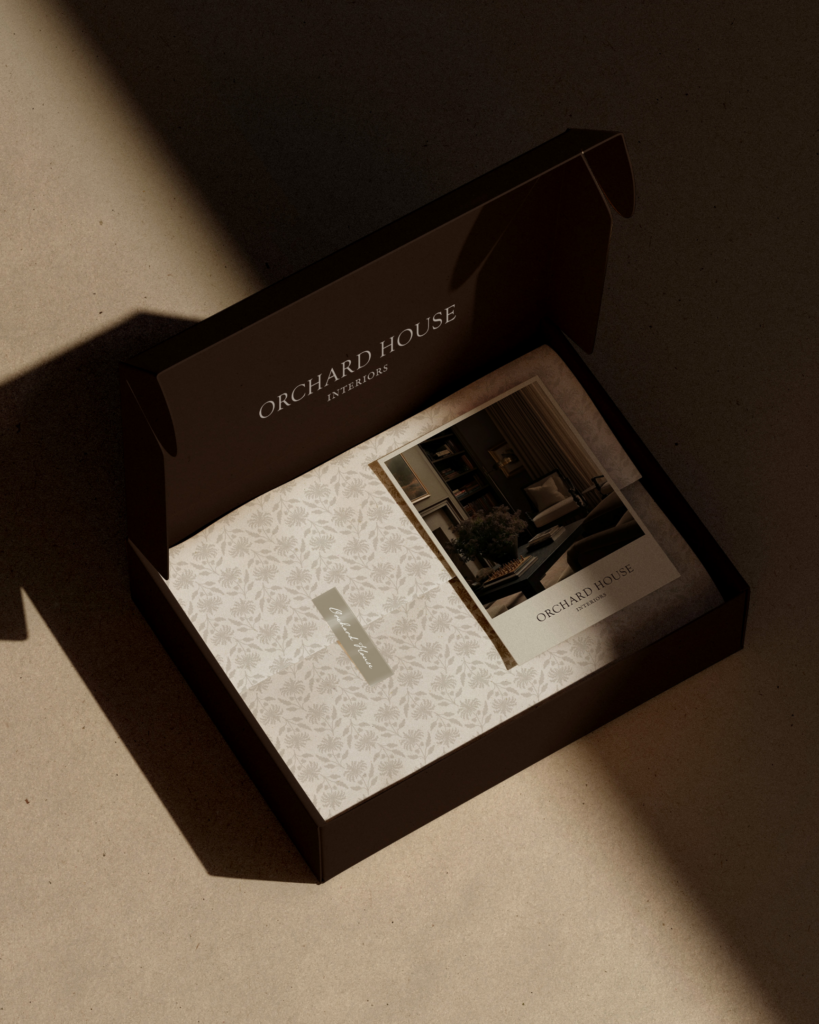 Luxury client onboarding package for Orchard House Interiors. Displays a branded presentation box with custom floral stationery and portfolio imagery, illustrating the premium brand experience.
